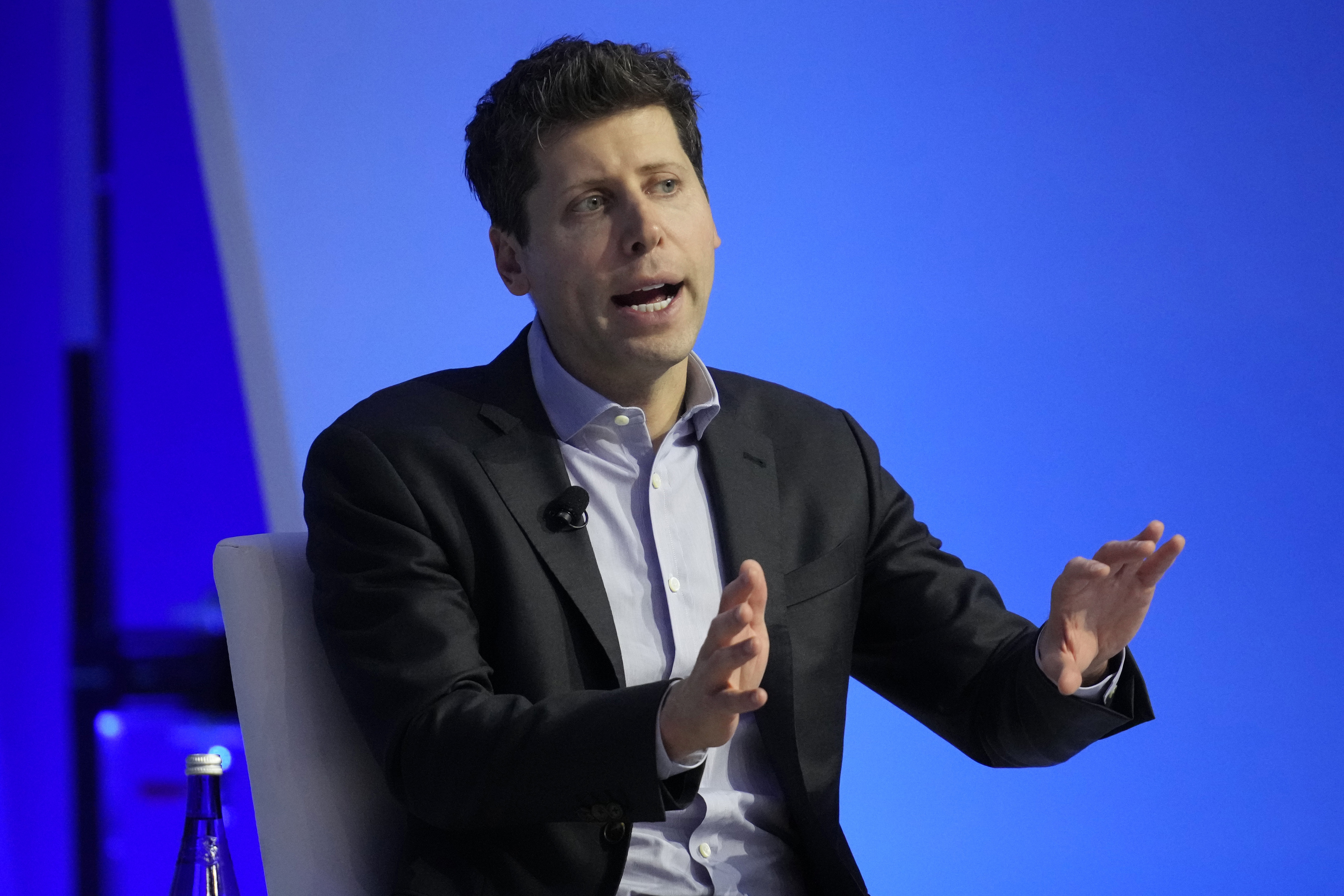 Sam Altman on stage at a conference